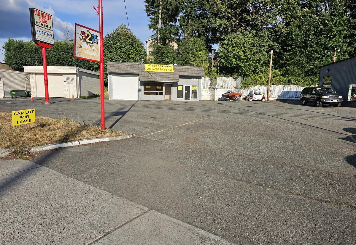 View from the sidewalk of the lot and building with the pole sign